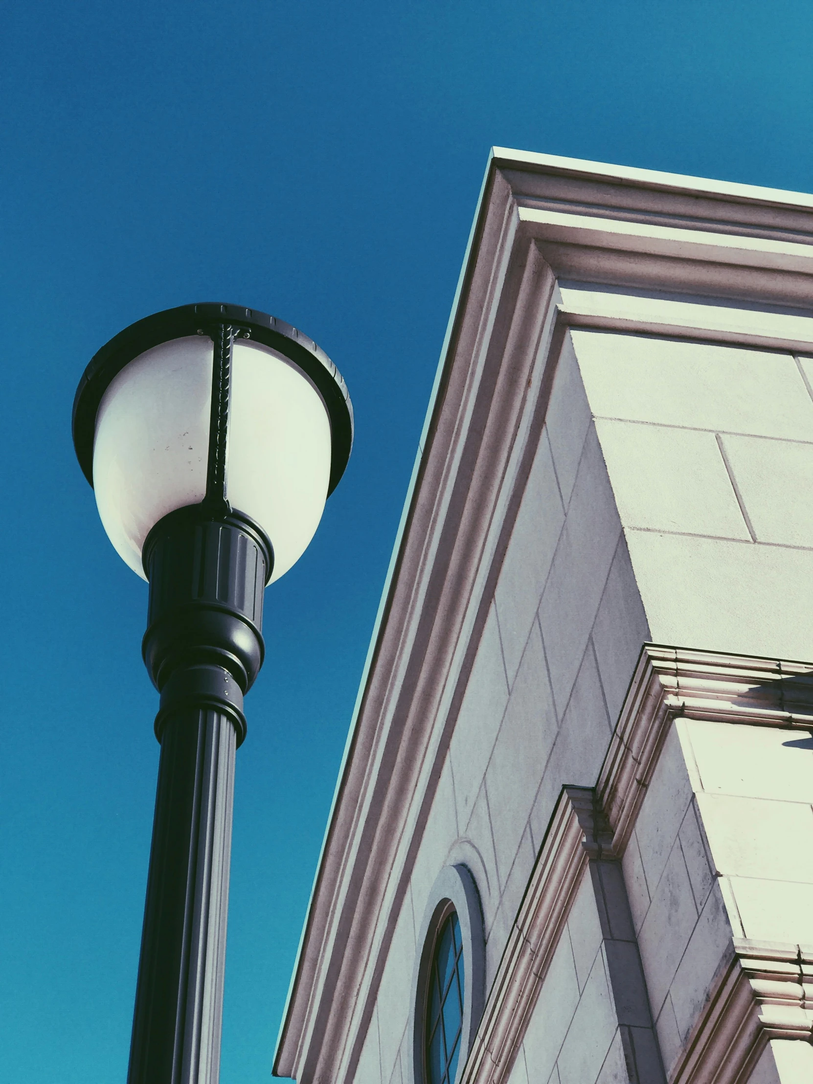 a street light sitting next to a tall building, by Carey Morris, unsplash, neoclassicism, clear blue skies, museum lighting, instagram picture, random detail