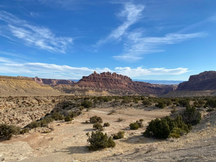 a view of the desert from the top of a hill, red peaks in the background, canyons, listing image, moab