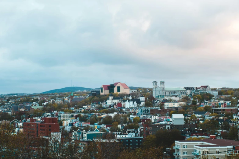 a view of a city from the top of a hill, pexels contest winner, mcgill, church in the background, vibrant but dreary, metallic