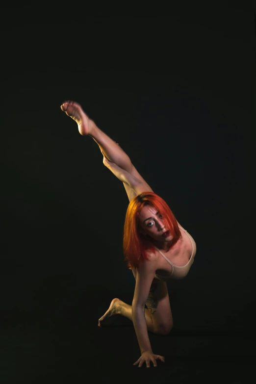 a woman doing a handstand pose against a black background, a portrait, inspired by Elizabeth Polunin, long orange hair floating on air, square, low quality photo, 15081959 21121991 01012000 4k