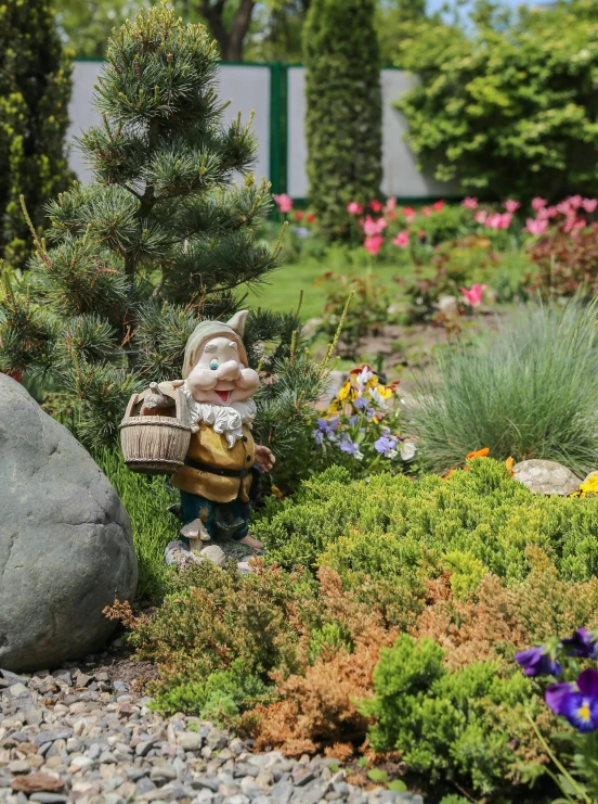 a gnome sitting on a rock in a garden, a statue, full of flowers, zoomed out to show entire image, bushes