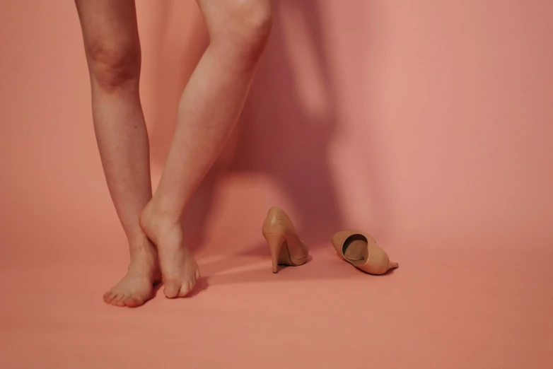 a woman standing next to a pair of shoes, by Elsa Bleda, magic realism, taupe, injured, lachlan bailey, showstudio