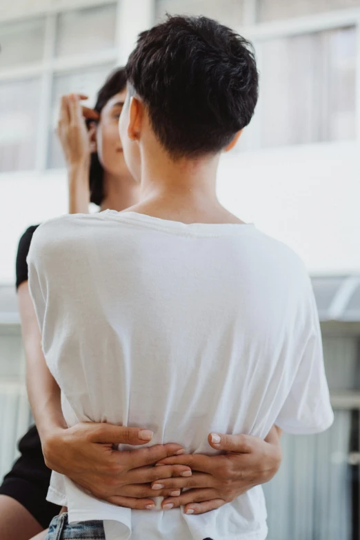 a man and a woman standing next to each other, by Nina Hamnett, unsplash, renaissance, wearing white leotard, lesbian embrace, louise zhang, showing her shoulder from back