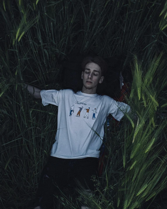 a young man laying in a field of tall grass, inspired by Elsa Bleda, unsplash, trending on r/streetwear, lil peep, embroidered shirt, night photo