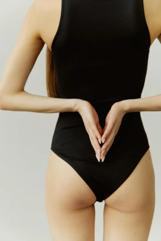 a woman in a black bodysuit making a heart with her hands, reddit, renaissance, bottom body close up, hand on hips, wearing leotard, editorial image