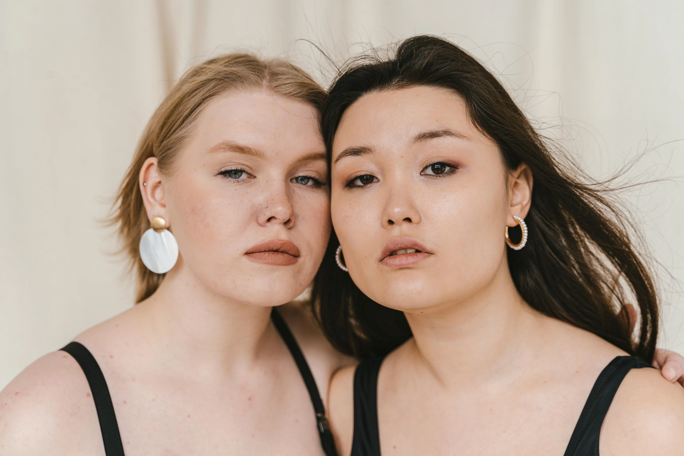 a couple of women standing next to each other, inspired by Wang Duo, trending on pexels, realism, huge earrings and queer make up, pale round face, ethnicity : japanese, julia hetta