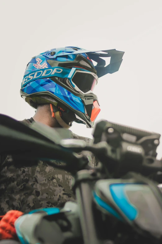 a close up of a person wearing a helmet on a motorcycle, profile image, off-roading, blue - grey gear, paintball world cup