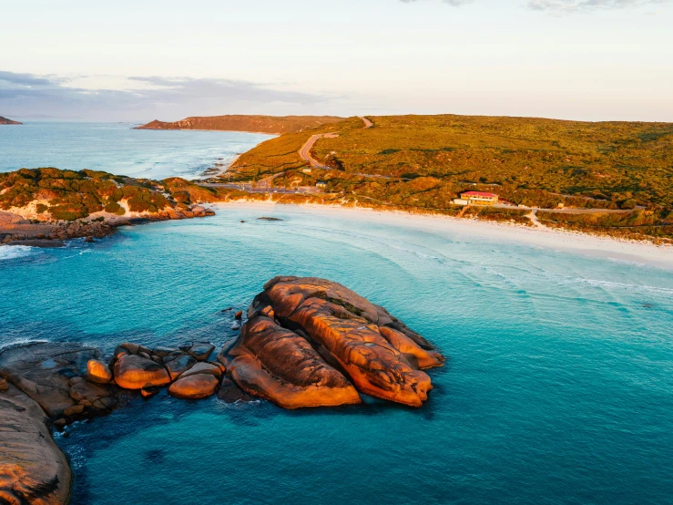 a large body of water next to a sandy beach, by Lee Loughridge, unsplash contest winner, manuka, an island made of red caviar, the emerald coast, evening sunlight