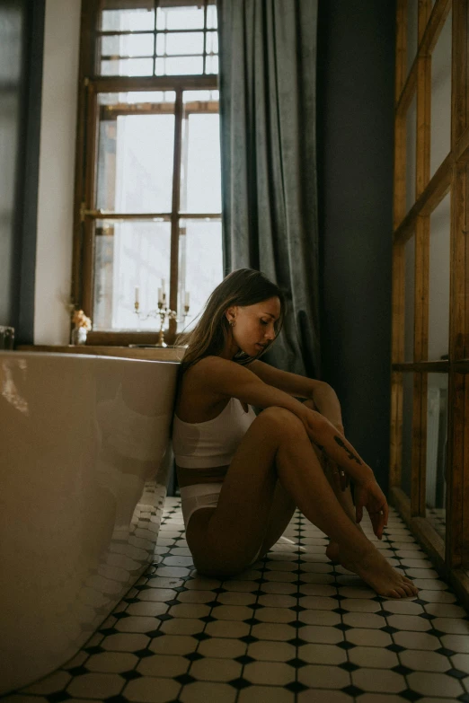 a woman sitting on the floor in front of a bathtub, inspired by Elsa Bleda, trending on pexels, renaissance, beautiful lonely girl, slightly tanned, sittin, late afternoon