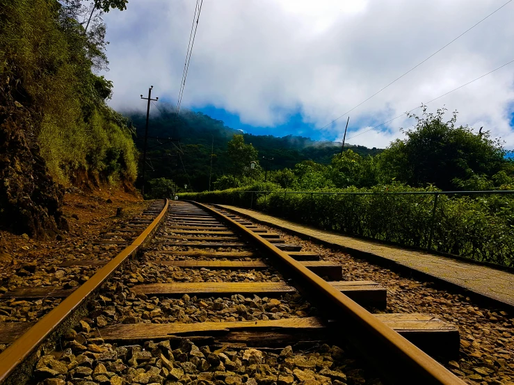 a train track with a mountain in the background, unsplash, hurufiyya, sri lanka, photo on iphone, low angle view, today\'s featured photograph 4k