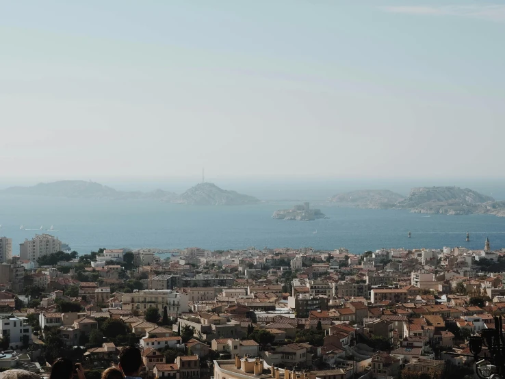 a group of people standing on top of a hill, pexels contest winner, hyperrealism, mediterranean city, a photo of the ocean, paisley, alvaro siza