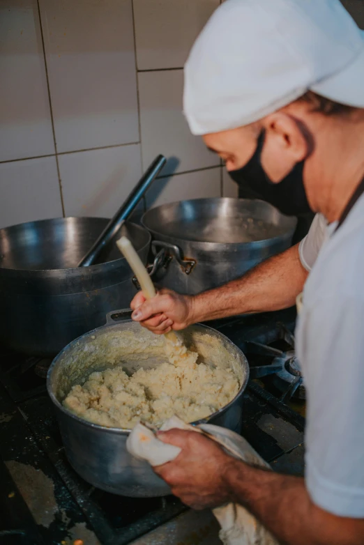 a man preparing food on a stove in a kitchen, mash potatoes, photograph taken in 2 0 2 0, mediterranean, thumbnail