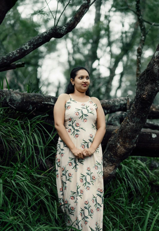 a woman standing next to a tree in a forest, by Elizabeth Durack, unsplash, hurufiyya, wearing a hawaiian dress, aged 2 5, portrait image, samoan features