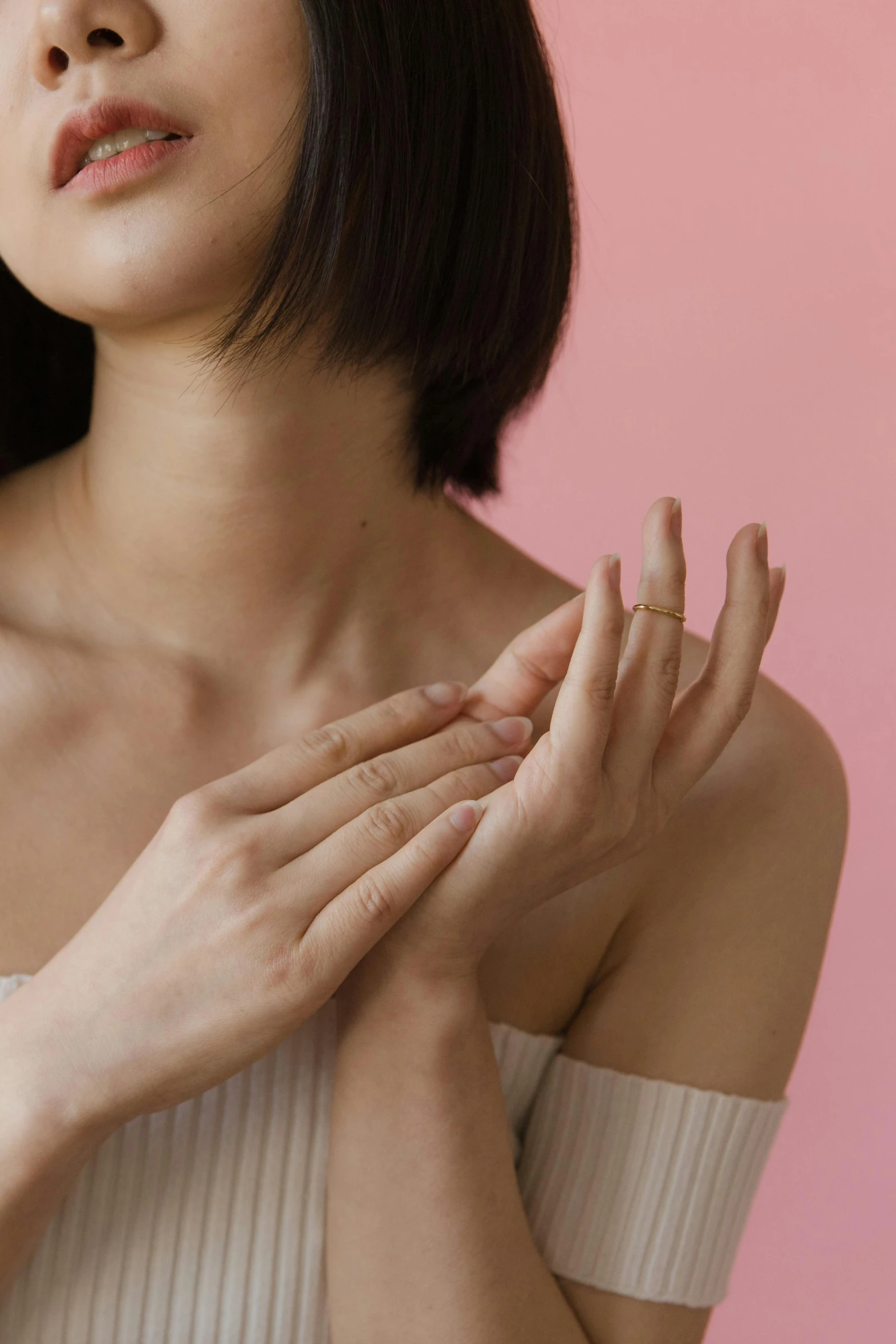 a woman holding her hands to her chest, trending on pexels, pink skin, louise zhang, essence, japanese