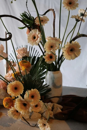 a bunch of flowers in a vase on a table, on display, shades of gold display naturally, palm, on location