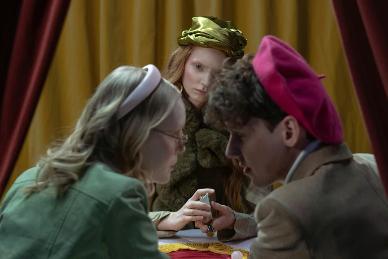 a group of people sitting around a table, a portrait, inspired by Wes Anderson, trending on pexels, magic realism, sadie sink, medium shot of two characters, goldilocks, cinestill 800t eastmancolor