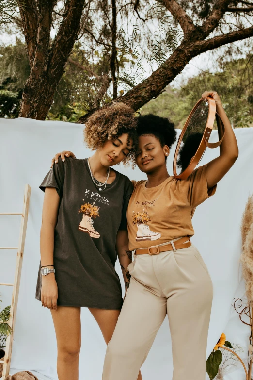 a couple of women standing next to each other, a cartoon, trending on unsplash, brown shirt, collection product, afropunk, outfit photo