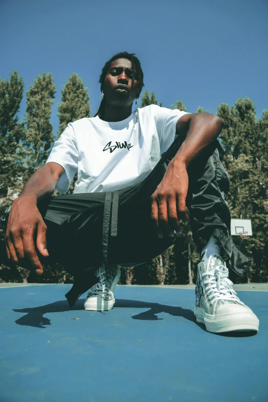 a man sitting on top of a tennis court holding a racquet, an album cover, unsplash, realism, gang clothing, offwhite, sneaker photo, graphic tees