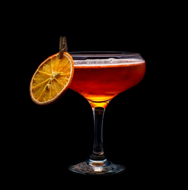 a drink sitting on top of a glass next to a slice of orange, inspired by Carlo Martini, pexels contest winner, renaissance, dark orange, bright on black, thumbnail, dolman