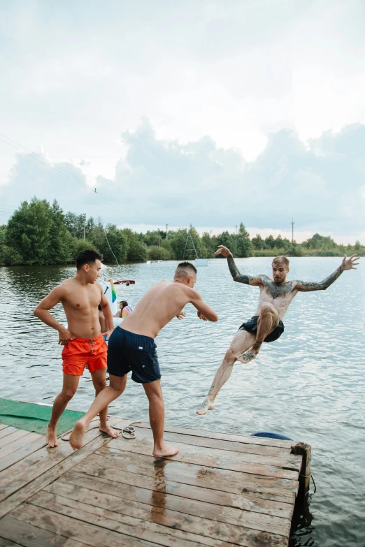 a group of men jumping into a body of water, in russia, vietnam, athletic tall handsome guys, photograph of three ravers