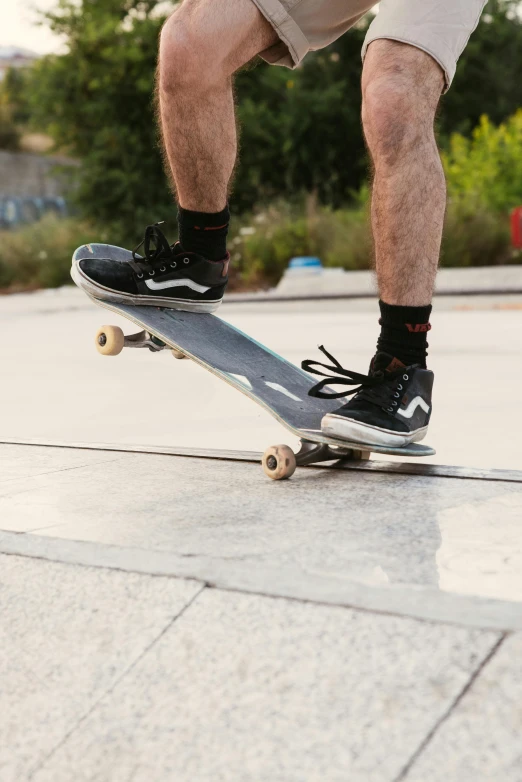 a man riding a skateboard up the side of a ramp, pexels contest winner, gray shorts and black socks, high technical detail, ad image, bows