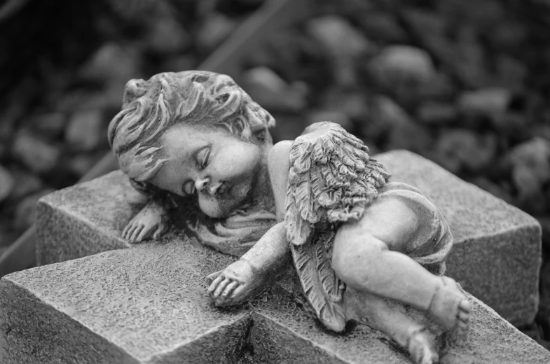 a black and white photo of a statue of a sleeping angel, pixabay contest winner, adorable, dead child, resting after a hard mission, bird eye view