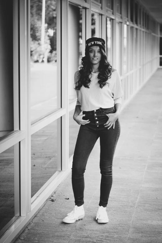 a black and white photo of a woman posing for a picture, a black and white photo, inspired by Anita Malfatti, ( ( ( wearing jeans ) ) ), at college, posing as a queen, waist long hair