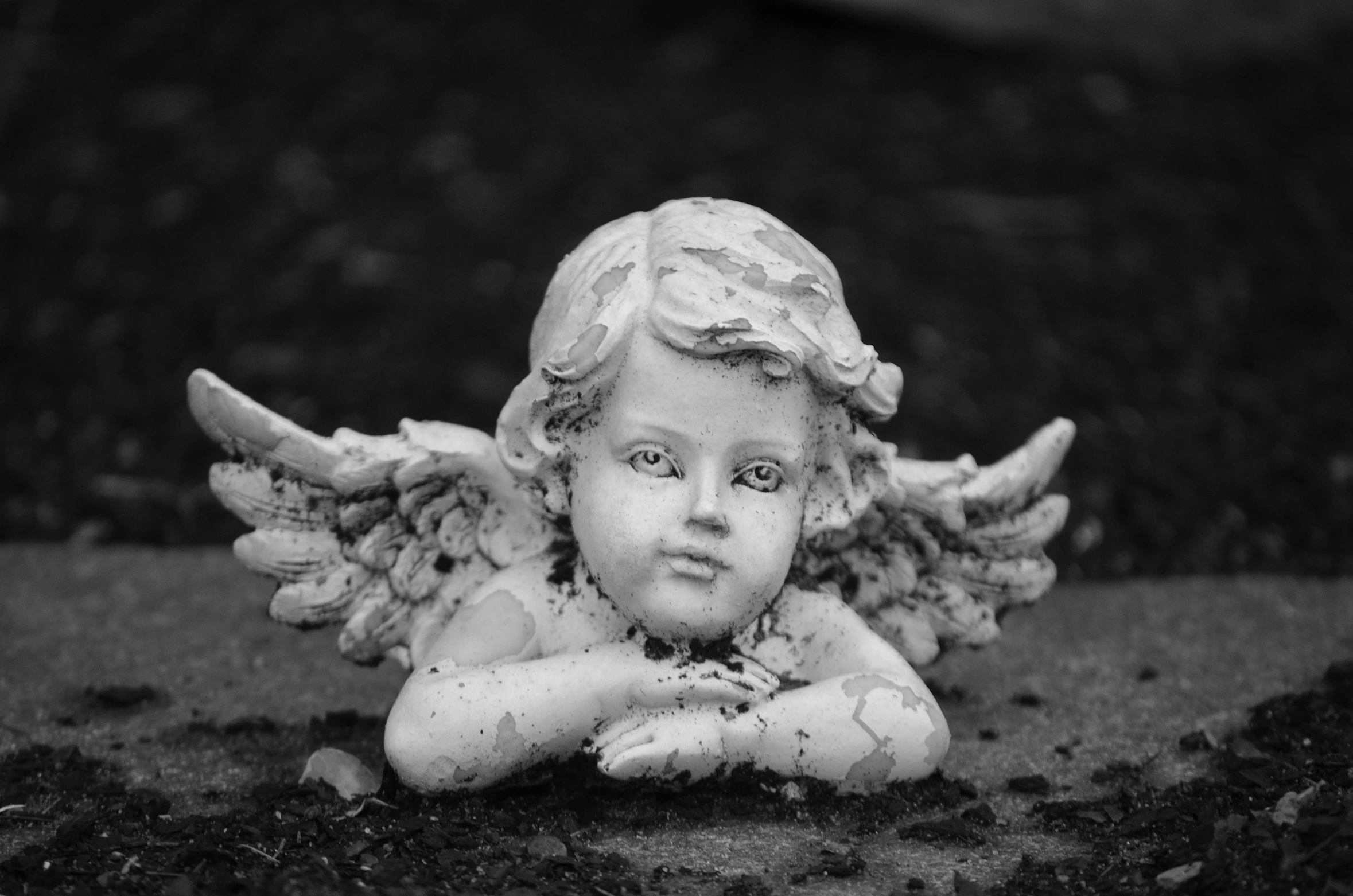 a statue of an angel laying on the ground, pixabay contest winner, icon black and white, innocent face, miniature porcelain model, damaged