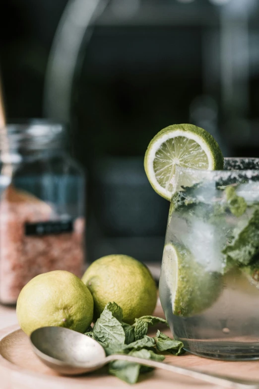 a close up of a drink in a glass on a table, a still life, trending on pexels, jar on a shelf, greens, lime, mixed materials