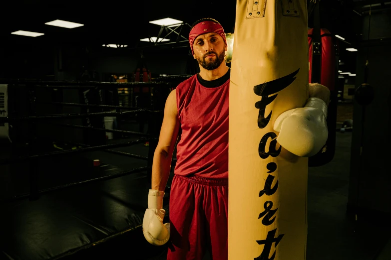 a man standing next to a punching bag, charlie day, profile image, sports photo, [ theatrical ]