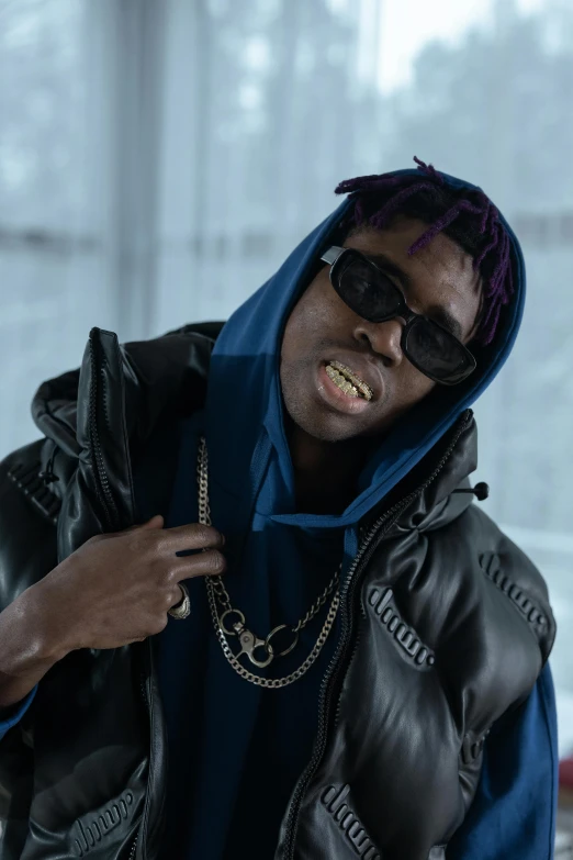 a close up of a person wearing a jacket and sunglasses, trending on pexels, afrofuturism, lil uzi vert, in a menacing pose, dark blue skin, dolman