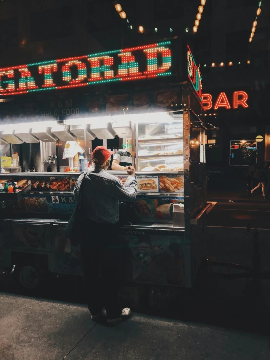 a man standing in front of a food stand, trending on unsplash, visual art, night time footage, el dorado, thumbnail, multiple stories