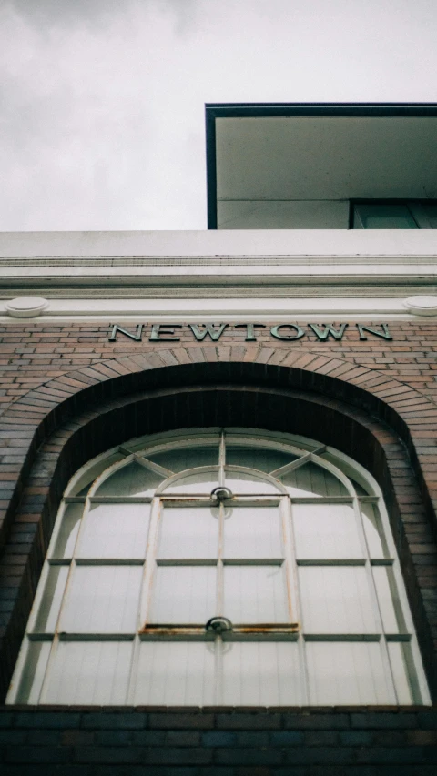 a clock mounted to the side of a brick building, by Andrew Stevovich, trending on unsplash, northwest school, all from the group nct, sign, neo classical architecture, doorway