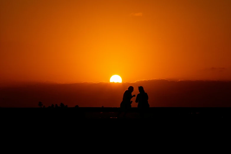 a couple of people standing on top of a beach at sunset, by Niko Henrichon, pexels contest winner, orange sun set, silhouette :7, during an eclipse, rooftop romantic