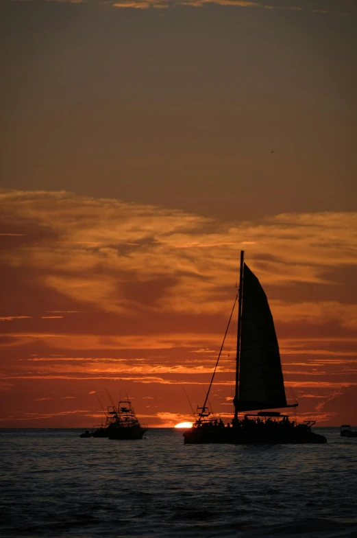 a couple of boats that are in the water, by Kristin Nelson, pexels contest winner, romanticism, silhouette over sunset, aruba, july 2 0 1 1, torn sails