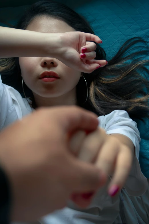 a woman laying on top of a bed next to a man, pexels contest winner, hyperrealism, partially cupping her hands, young asian girl, high angle close up shot, hands shielding face