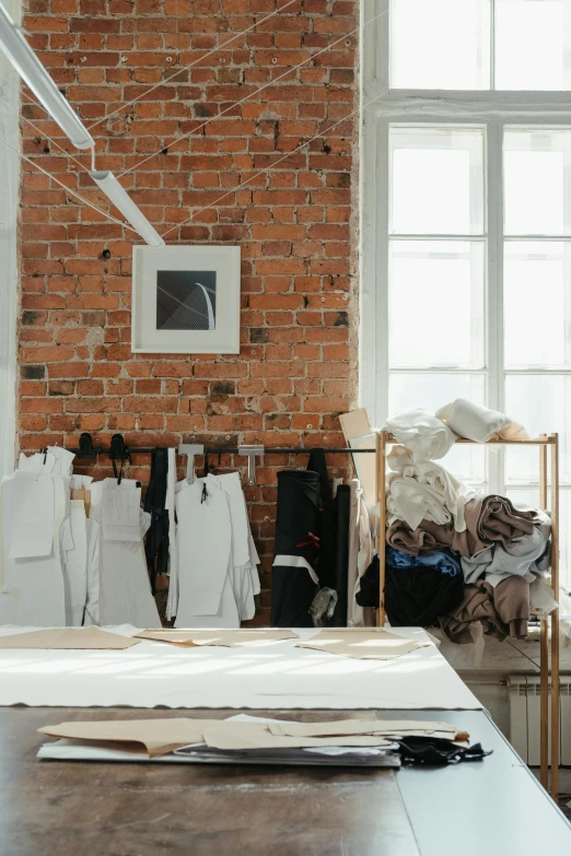 a table that has a bunch of clothes on it, trending on unsplash, process art, inside a grand studio, white apron, ignant, serious business