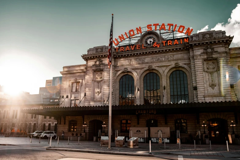 a train station with cars parked in front of it, by Meredith Dillman, unsplash contest winner, ornate carved architecture, colorado, 💋 💄 👠 👗, orange line