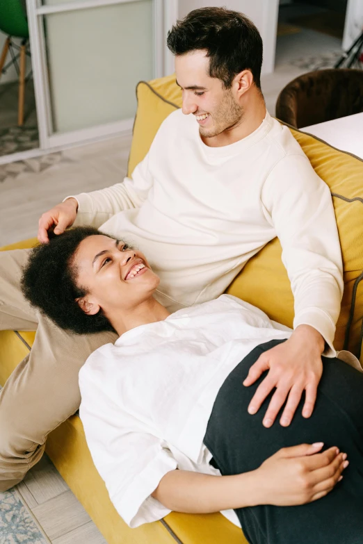 a man and a woman laying on a couch, pexels contest winner, renaissance, membrane pregnancy sac, smiling at each other, plain background, diverse