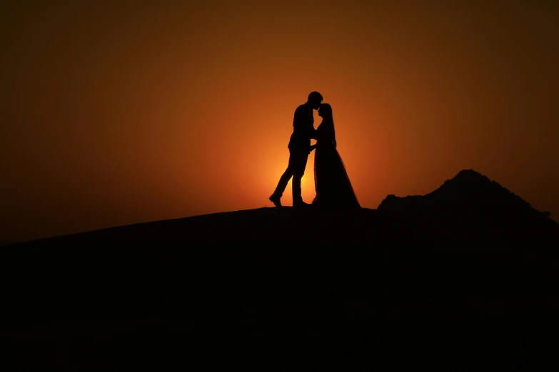 a couple standing on top of a hill at sunset, by Max Dauthendey, pexels contest winner, romanticism, arabian night, studio photo, kissing, today\'s featured photograph 4k