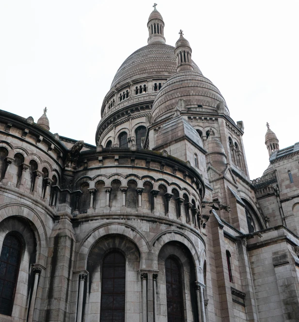 a very tall building with a clock on it's side, a photo, pexels contest winner, paris school, background basilica! sacre coeur, under a gray foggy sky, view from the side, high details