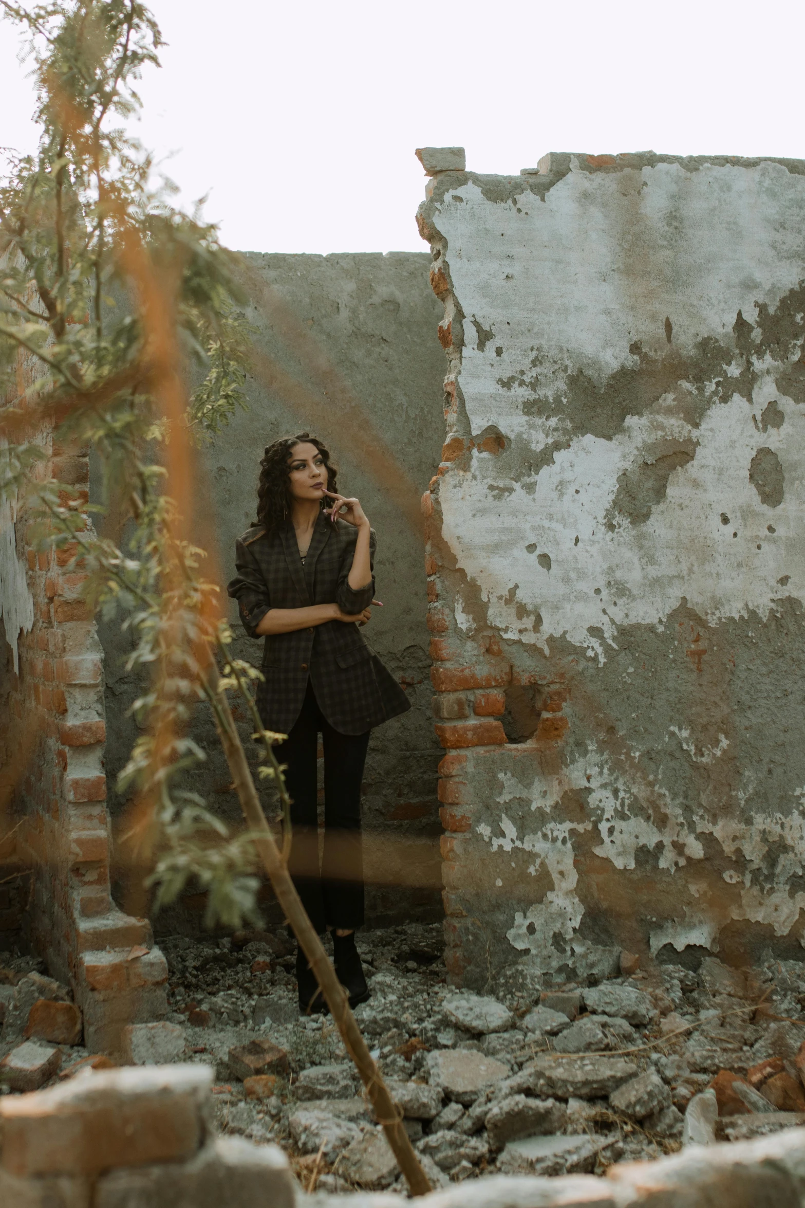 a woman standing in the ruins of a building, inspired by Elsa Bleda, low quality photo, musician, settlement, promotional image