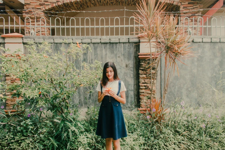 a woman standing in front of a brick building, pexels contest winner, in the garden, avatar image, asian girl, 90s photo