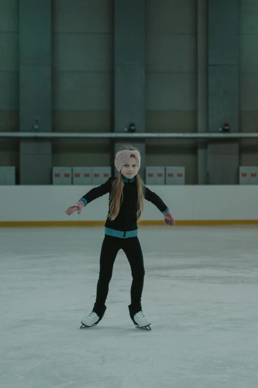 a little girl skating on an ice rink, inspired by Louisa Matthíasdóttir, antipodeans, still from a live action movie, hyper realistic”, skintight suits, with black beanie on head