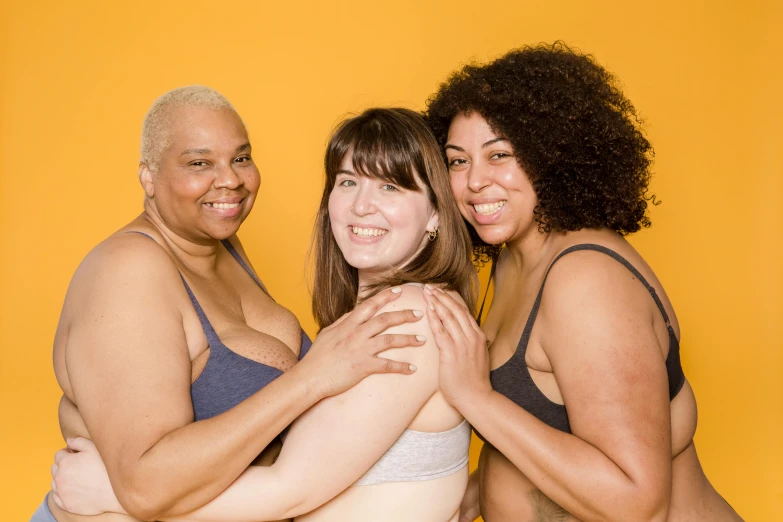 a group of three women standing next to each other, by Arabella Rankin, unsplash, posing together in bra, yellow skin, burly, grey