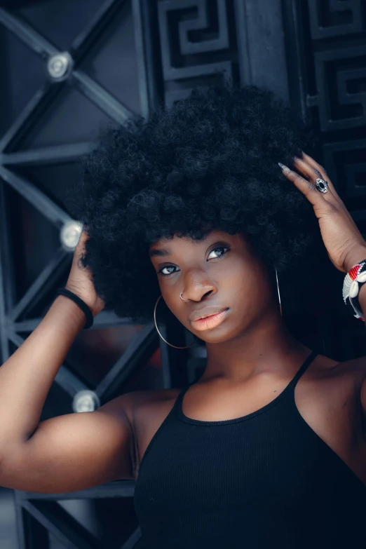 a woman with an afro is posing for a picture, by Lily Delissa Joseph, pexels contest winner, black bangs, maria borges, silky texture, ( ( dark skin ) )