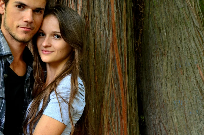 a man and a woman leaning against a tree, a picture, by Nándor Katona, pexels contest winner, renaissance, attractive girl, red woods canopy love, middle close up shot, a wooden