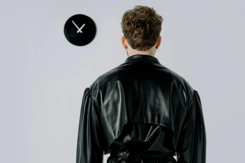 a man in a leather jacket looking at a clock, inspired by Robert Mapplethorpe, trending on pexels, suprematism, thin black robe, back to back, ignant, portrait of an android