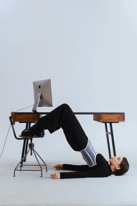 a man laying on the floor in front of a computer, inspired by Sarah Lucas, unsplash, computer art, standing on two legs, office clothes, minimalist furniture, back arched
