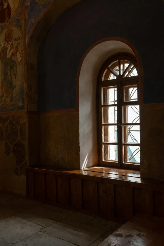 a room with a window and a bench in it, inspired by Andrei Rublev, unsplash, romanesque, wooden trim, side light, byzantine, stained